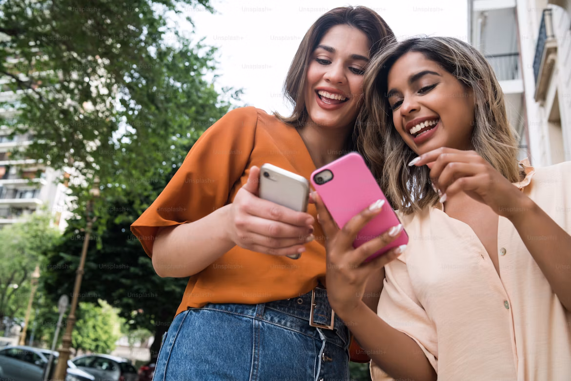 Friends smiling while chatting on phone